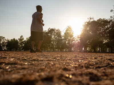 农村运动草亚洲高年长男子在日落天空背景的公园里慢跑健康生活方式和保健概念图片