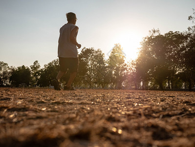 亚洲高年长男子在日落天空背景的公园里慢跑健康生活方式和保健概念跑步走锻炼图片