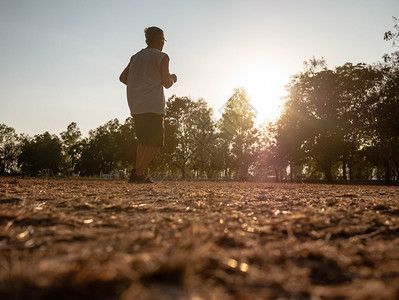 训练场地松弛亚洲高年长男子在日落天空背景的公园里慢跑健康生活方式和保健概念图片