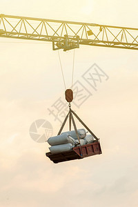 控制在建筑工地背景中的天空一个旧锤头起重机吊水泥袋托盘材料亚洲图片