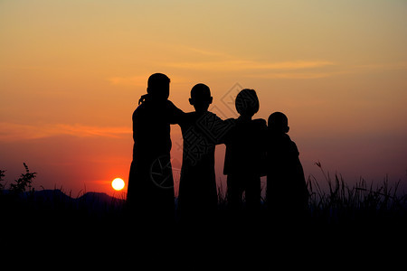 暮四个孩子一起站在日落时空的天在日落背景下假期学校图片