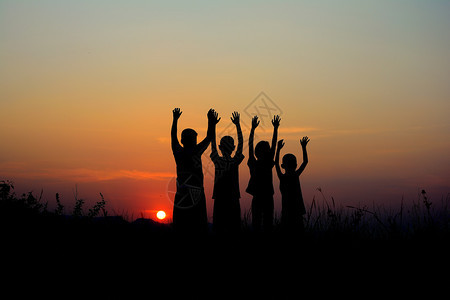 年轻的自然乐趣四个孩子一起站在日落时空的天在日落背景下图片