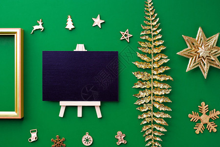 黑色板顶视图有黄金圣诞节和新年装饰品在绿色纸背景上举行庆祝节日贺卡式表演以展示设计派对前夕假日图片