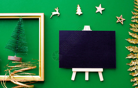 假日黑色板顶视图有黄金圣诞节和新年装饰品在绿色纸背景上举行庆祝节日贺卡式表演以展示设计奢华假期图片