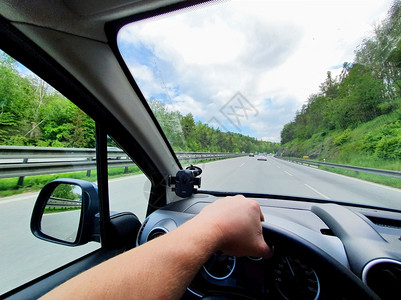 男运动绿色司机在车内驾驶汽时从内部看到驾驶员的视角司机手持方向盘在白天POV中时驾驶高速公路图片