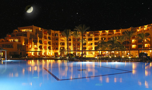 水池畔透明月亮在度假村酒店和游泳池的夜晚和上酒店在度假晚上酒店的灯光在晚上泳池水中反射图片