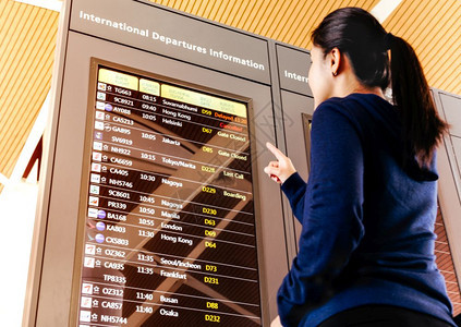 ShanghhaiChinaFEB2019女旅行者在机场候站检查飞行时间表运输航班手提箱图片
