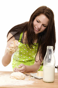 年轻女子在面团里加粉快乐的年轻女子在白色背景下面团里加粉来临生的食物图片
