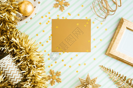 奢华假期圣诞快乐和新年金贺卡观赏在绿条线桌礼堂庆祝贺卡式模型展示设计时闪亮的金银罐球彩珠装饰品展出标签图片