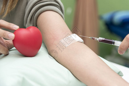 抽血医生经过院护士用红心验血和捐概念在医院收集血液以及医院和保健概念的红心血液测试检查和捐赠概念注射器图片