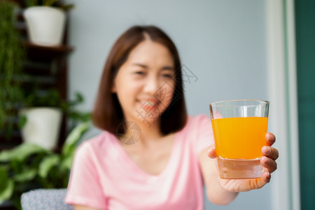 功能自然维他命中年亚洲妇女阅读一本书在家中拿橙汁杯健康保概念和为康而吃东西图片