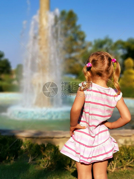 复制白天后部学龄前小女孩观看喷泉后年轻女孩喜欢夏天外出好奇心金发的美女看着流水的小滴子享受节日快乐漂亮孩子摄影图片