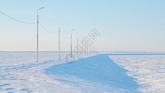 电缆最起码的风景沿一条乡村公路上有街道灯光在雪田中以面糊色标着雪地白的极简主义者图片