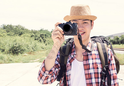 成人森林一个有背包的英俊亚裔男子拿着照相机拍在暑假旅行时用复印空间拍摄一张照片假期图片