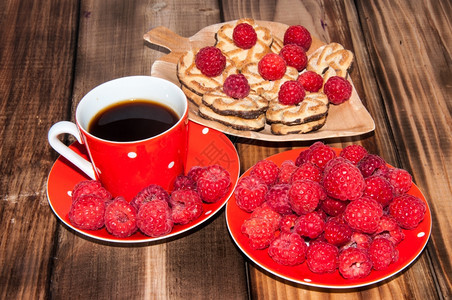 旧木制桌子顶端的红莓和咖啡杯果味卡布奇诺喝图片