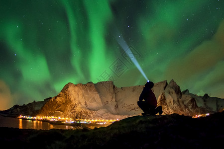 少量冰岛观光客正在察奥罗亚北极光点在奥尔斯汀登上空这是一块惊人的岩石靠近挪威奥尔斯汀登上空的挪威洛福滕群岛里纳村天空图片