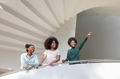 家庭美国人非裔族群青少年在建筑上仰望螺旋阶梯而远行离开图片