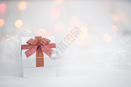 白色毛皮bokeh背景的礼品盒有季节问候新年快乐AF点选择的复制空间模糊散景粉色的闪亮图片