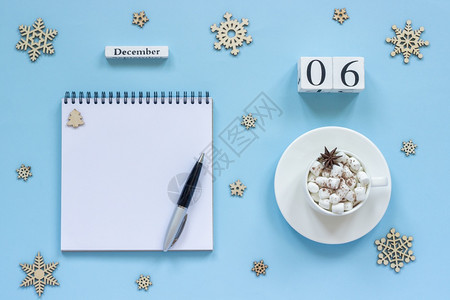 备忘录饮料12月6日含棉花糖和恒星火的可杯用笔纸和雪花在蓝背景上空开的注解纸用笔和雪花放在蓝色背景上的白纸条Flatflatsh图片