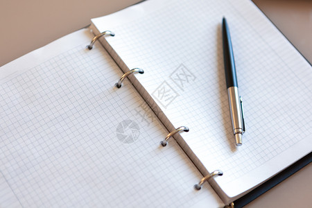 干净的提醒打开笔记本用放在银括号上的米格桌面笔纸页上银色黑概念业务中的自动圆点笔在家工作复制空间顶视图特写银黑色背景图片