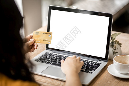 在职的安全手持信用卡零笔记本电脑工作像背景一样在咖啡店用空白屏的笔记本电脑做工网上付费购物Onlinepayshopping商业图片