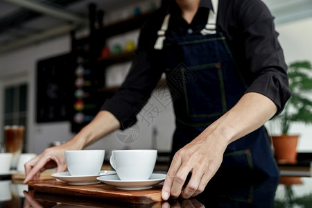 机器马克杯泰国咖啡店制造商手持机上的有选择焦点白咖啡杯因图片