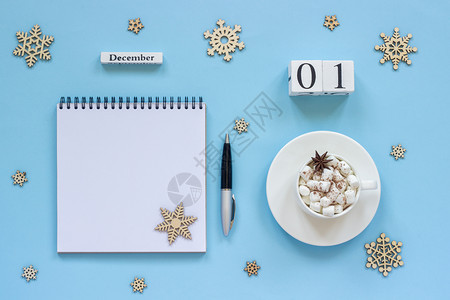 备忘录12月日一杯含棉花糖和恒星火的可杯用笔纸和雪花在蓝背景上空开的注解板用笔纸和雪花放在蓝色背景上的白纸条Flatflatpl图片