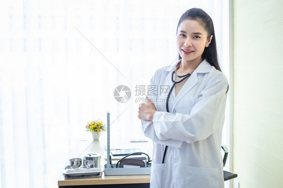 亚洲年轻女医生用听诊器和院背景的正面情绪将她双臂折叠起来年轻的淑女孩图片
