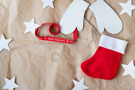12月5日红丝带上写着圣诞快乐和手套红袜子在工艺纸上展开12日题词地点颜色模糊装饰风格图片