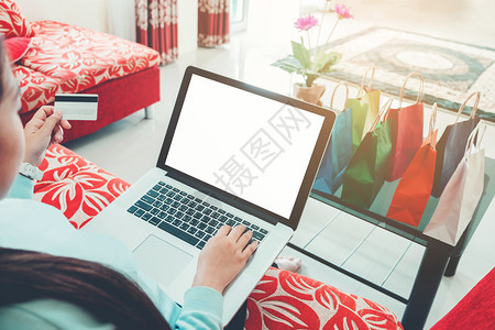 订购贸易支付利用带空白屏幕的笔记本电脑在家享受信用卡网上购物的妇女图片
