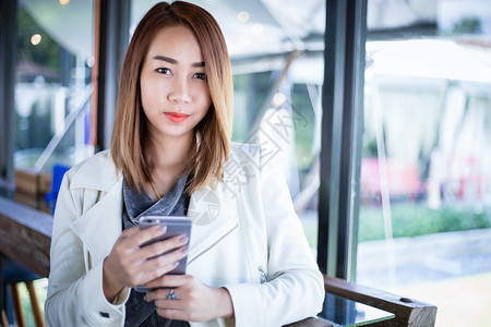 使用电话在线购物和自由时间在咖啡店用手机打电话的女亚洲人Asiian白色的女孩内部图片