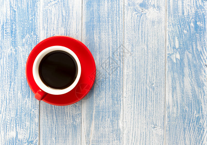 可口目的蓝色木制桌上红杯咖啡带有复制空间的顶视图细节图片
