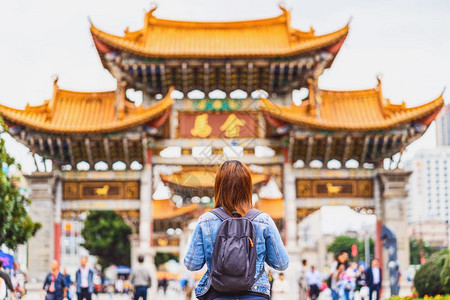 女团体穿过金比广场昆明旅行和游瓷华文化以及传统著名地点和里程碑式概念时看望和观光的亚洲背包妇女面金碧图片