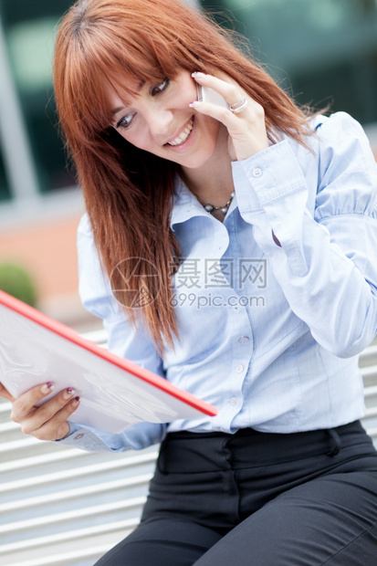 移动的红发女商人坐在金属长椅上打来电话的商机照片年轻办公室图片