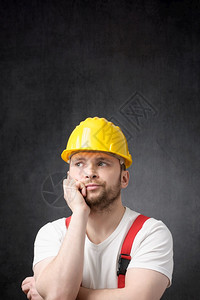 男戴着黄色安全帽的不开心建筑工人戴着黄色安全帽的失望建筑工人设者恼火图片