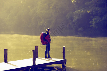 女背包者钦佩在泰国马宏松省MeeHongSon湖PangOung湖的美丽绿树和金光庞地标洪图片