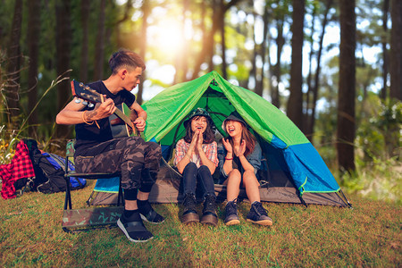 旅行一群朋友在夏日露营时一起喝酒弹吉他图片