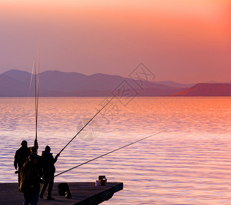 白种人垂钓者积极的夕阳下钓鱼渔夫剪影夕阳下钓鱼的渔夫剪影图片
