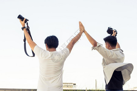 尽管手男游客用照相机拍而旅游行是泰国的风景照片泰国有一群男子在泰国河边站立拍摄照片在泰国河边站着拍照年轻的图片
