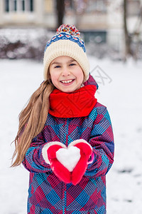 红手套的女孩拿着一颗心型雪球象征着爱华伦天人之情一红手套的女孩拿着心型雪球爱情的象征一种保持孩子图片