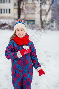 假期圣诞节红手套的女孩拿着一颗心型雪球象征着爱华伦天人之情一红手套的女孩拿着心型雪球爱情的象征人节图片