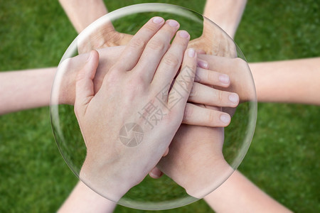 联合的组织沟通双手在草地上结为一团并合于玻璃球中图片