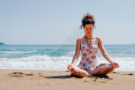夏服女青年在海边滩或做瑜伽冥想在阳光明媚的白天拉伸冥想放松莲花的位置合十礼正念体式图片