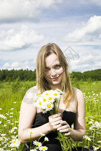 活动在草地上鲜花的年轻女子愉快植物图片