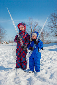 俏皮快乐的兄妹在冬季散步公园里玩雪球肖像手套图片