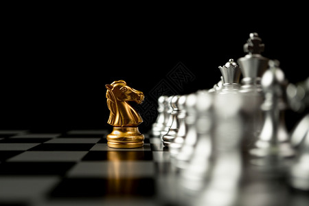 公司的王冠站在其他象棋前的金马领袖概念必须具有勇气和挑战在竞争领导才能和商业愿景方面有勇气和挑战以便赢得商业游戏的胜利棋盘图片