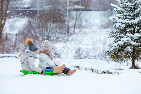 冬天可爱的小女孩享受雪橇滑孩子们在地游和户外玩戏在圣诞节前夕家庭渡假圣诞晚夜露户外可喜的小快乐女孩在冬季雪天滑十二月童年图片