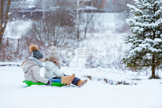 冬天可爱的小女孩享受雪橇滑孩子们在地游和户外玩戏在圣诞节前夕家庭渡假圣诞晚夜露户外可喜的小快乐女孩在冬季雪天滑十二月童年图片