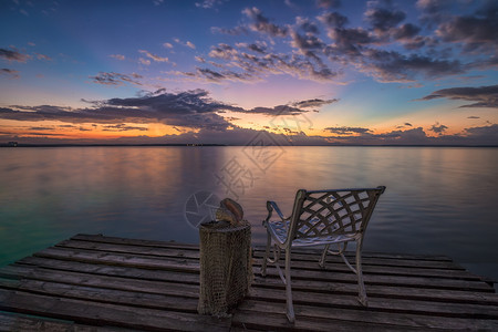 空椅子在木制码头上等待海边日出风景优美水采取图片