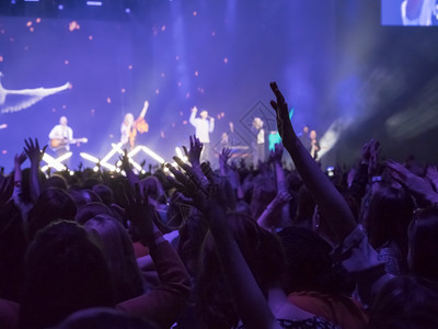 观众用双手在音乐节上举起手来灯光从舞台上下流而节日晚上韵律图片